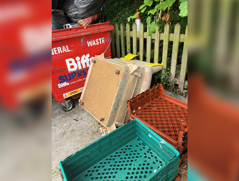 Some fly-tipped furniture next to a general waste bin